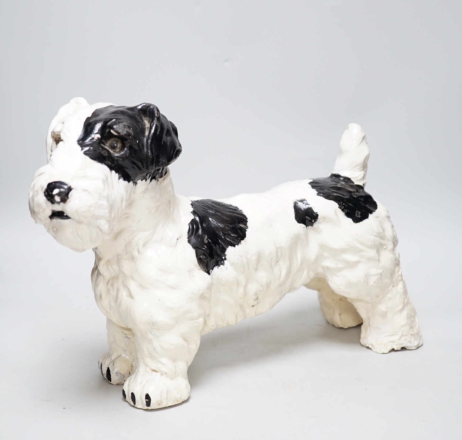 A painted plaster model of a terrier dog, 28cm high, 41cm long